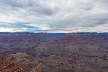 Fototapeta na wymiar Panoramic aerial view from South Kaibab hiking trail at South Rim of Grand Canyon National Park, Arizona, USA, America. Colorado River weaving through valleys and rugged terrain. Clouds and overcast.