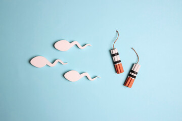 Spermatozoa with cigarette dynamite bomb on a blue background.