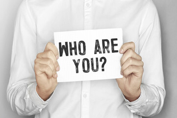 Man holding a paper card with text Who are you