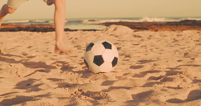 Child playing football on the beach, family fun outdoors players in soccer in dynamic action have fun playing football in summer day under sunlight.