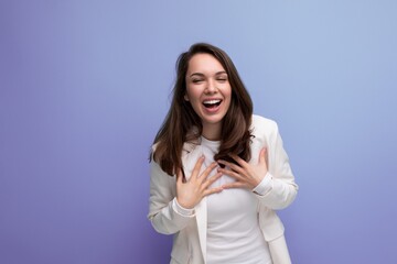 cheerful brunette woman in ivory jacket and white dress posing in studio