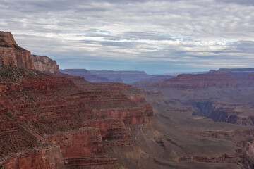 Panoramic aerial view from South Kaibab hiking trail at South Rim of Grand Canyon National Park, Arizona, USA, America. Colorado River weaving through valleys and rugged terrain. Clouds and overcast.