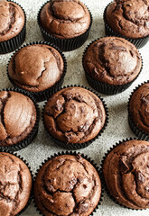 Chocolate muffins on a white table. Homemade delicious chocolate cupcake on a light background close-up from above, selective focus.