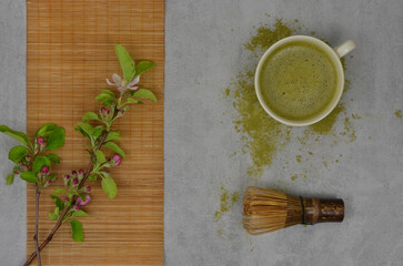 Japanese, green matcha. Hot tea with matcha powder, bamboo broom and green twig with flowers. Flat lay.