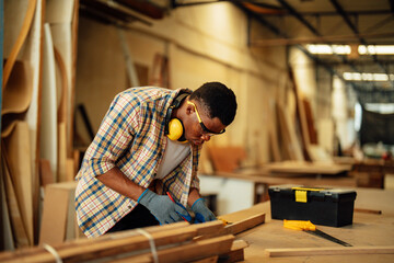 Carpenter man attend to making masterpiece woodworks handcrafted furniture fine measure in wood workshop.