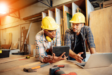 Two Carpenter working on wood craft at workshop to produce construction material or wooden furniture. The young carpenter use professional tools for crafting. DIY maker and carpentry work concept.