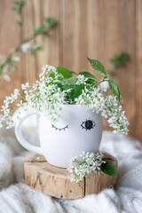 A cup of warm, warming aromatic tea, coffee, flowers nearby