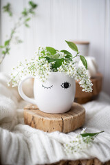 A cup of warm, warming aromatic tea, coffee, flowers nearby