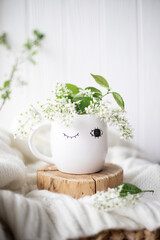 A cup of warm, warming aromatic tea, coffee, flowers nearby