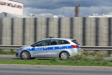 Radiowóz policyjny w trakcie pościgu, jadący na sygnale - obrazy, fototapety, plakaty