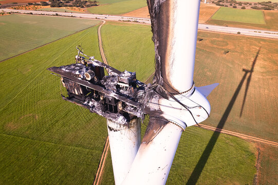 Elevated front view of the Striking Panorama of a Burned-Out Wind Turbine in a wind farm. Close-up on wind turbine destroyed by fire after a lightning strike. Windmill over heated and set fire. Spain