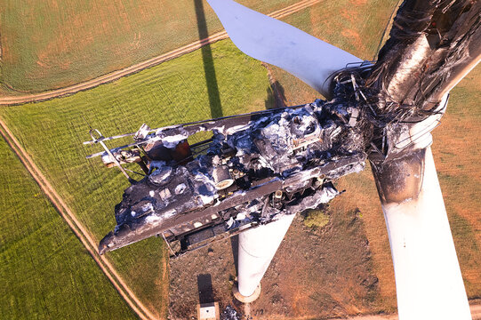 Aerial view on top of the Striking Panorama of a Burned-Out Wind Turbine in a wind farm. Close-up on wind turbine destroyed by fire after a lightning strike. Windmill over heated and set fire. Spain