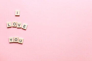 Design I love you made of wooden letters on a pink background. Flatly i love you. Flat lay valentines day
