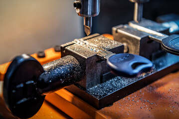 Locksmith in workshop makes new key duplicate