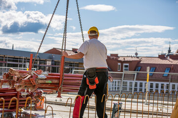 Worker operating a crane in a production facility.