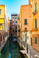 Fototapeta na wymiar Narrow canals of Venice city with old traditional architecture, bridges and boats, Veneto, Italy. Tourism concept. Architecture and landmark of Venice. Cozy cityscape of Venice.