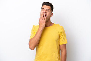 Young caucasian man isolated on white background yawning and covering wide open mouth with hand