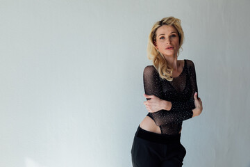 Fototapeta premium beautiful blonde in black fashionable clothes on a white background