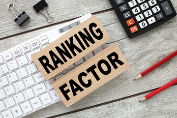 RANKING FACTOR text on wooden blocks on a gray background. bars on white keyboard