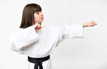 Little caucasian girl over isolated white background doing karate © luismolinero