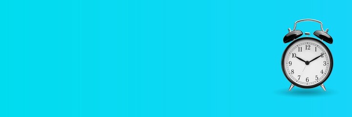 Black alarm clock over turquoise blue background with copy space. Time management concept.