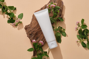 A brown tree branch with cosmetic tube leaning on and displayed with some Lantana camara flowers....