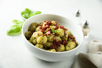 Homemade potato gnocchi with pesto and sausage 
