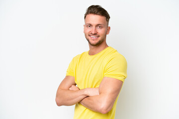 Young blonde caucasian man isolated on white background with arms crossed and looking forward