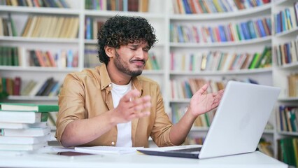 Frustrated student complains about laptop not working or computer program crashing while sitting in campus library space. Angry teacher is unhappy with the internet connection or poor online service - Powered by Adobe