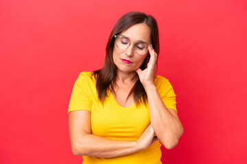 Middle-aged caucasian woman isolated on red background with headache