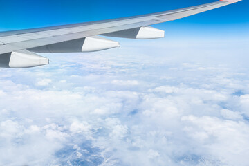 Obraz premium View from the airplane window. The wing of an aircraft during a flight in daylight at high altitude.