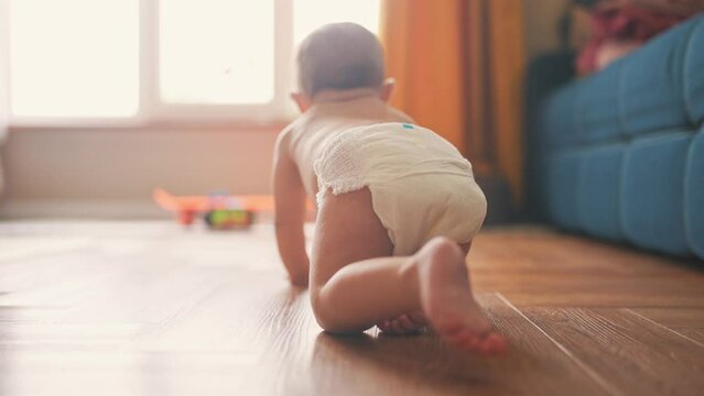 baby son crawling. happy family a first steps kid dream concept. baby newborn crawling down the hallway in the house. happy baby boy crawling on the floor takes her first steps lifestyle