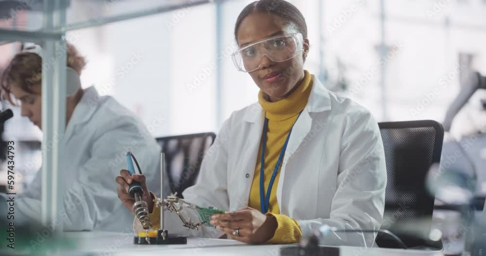 Fototapete Diverse Team of Multiethnic Young Scientists Passing Internship in a Modern High Tech Laboratory. Cute African Female Looking at Camera and Smiling while Working with Soldering Iron