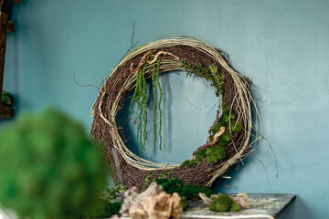 Close-up of home wall decor made of natural materials.Wreath of twigs, driftwood,stabilized moss and leaves.Biophilia design concept.
