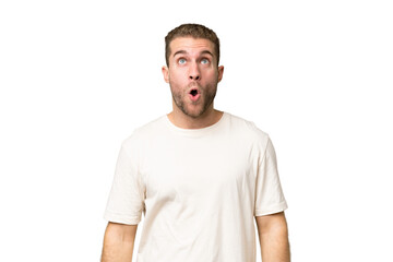 Obraz premium Young handsome caucasian man isolated on green chroma background looking up and with surprised expression