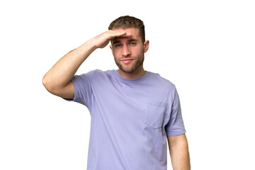 Fototapeta premium Young handsome caucasian man isolated on green chroma background looking far away with hand to look something