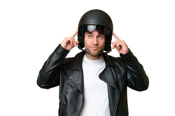 Young caucasian man with a motorcycle helmet isolated on green chroma background having doubts and thinking