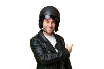 Young caucasian man with a motorcycle helmet isolated on green chroma background pointing back