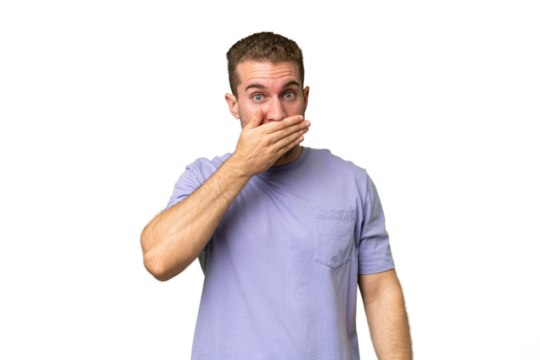 Young handsome caucasian man isolated on green chroma background covering mouth with hand