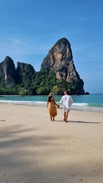 Railay Beach Krabi Thailand, the tropical beach of Railay Krabi, a couple of men and women on the beach, Panoramic view of idyllic Railay Beach in Thailand with a traditional long boat. 
