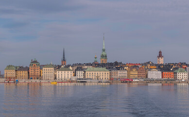 Obraz premium The old town Gamla Stan with 1700s houses and churches at the water front, a tranquil early sunny spring day in Stockholm