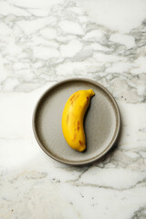 Banana dessert in a wooden bowl on marble table