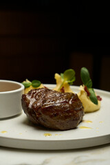 Beef stew and mashed potato with sauce on a white plate,