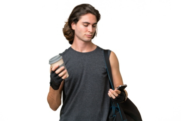 Young sport handsome man isolated on green chroma background holding coffee to take away and a mobile