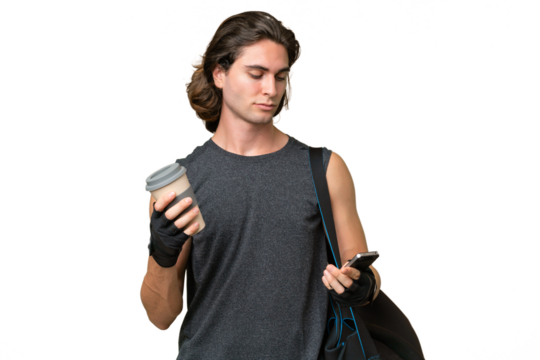 Young sport handsome man isolated on green chroma background holding coffee to take away and a mobile