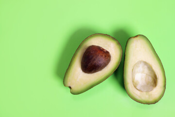 Sliced avocado on a green background, the concept of weight loss, proper nutrition
