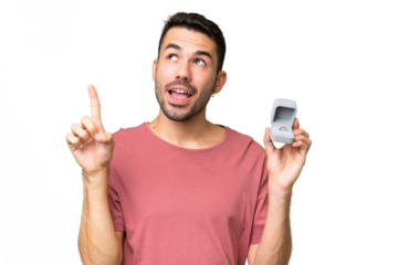 Young handsome caucasian man holding a engagement ring over isolated background intending to realizes the solution while lifting a finger up