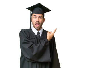 Young university graduate man over isolated background surprised and pointing side