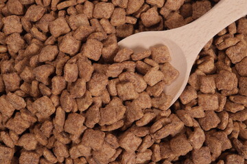 Chocolate snacks, dry breakfast, pillows in a wooden spoon