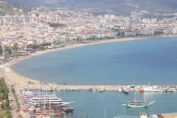 Fototapeta premium Landscape with marina on Alanya peninsula, Antalya region, Turkey, Asia. Famous tourist destination with high mountains. Part of the ancient old castle. Summer bright day.